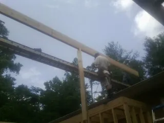 Carpenter setting a ridge beam over a new addition frame — Ice Dam Removal by Roofing Brothers in Riesel