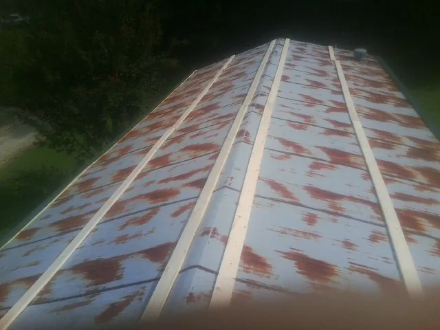Rusted metal roof panels with new wood purlins before replacement — Storm Damage Roof Repair in Riesel by Roofing Brothers