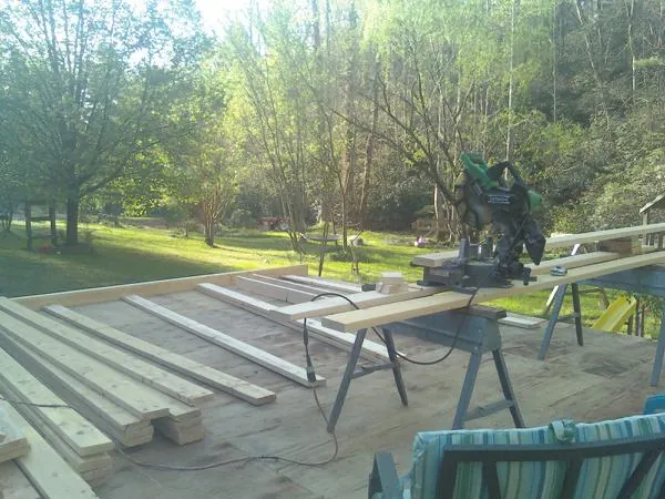 Miter saw and framing lumber on a deck under construction in Riesel