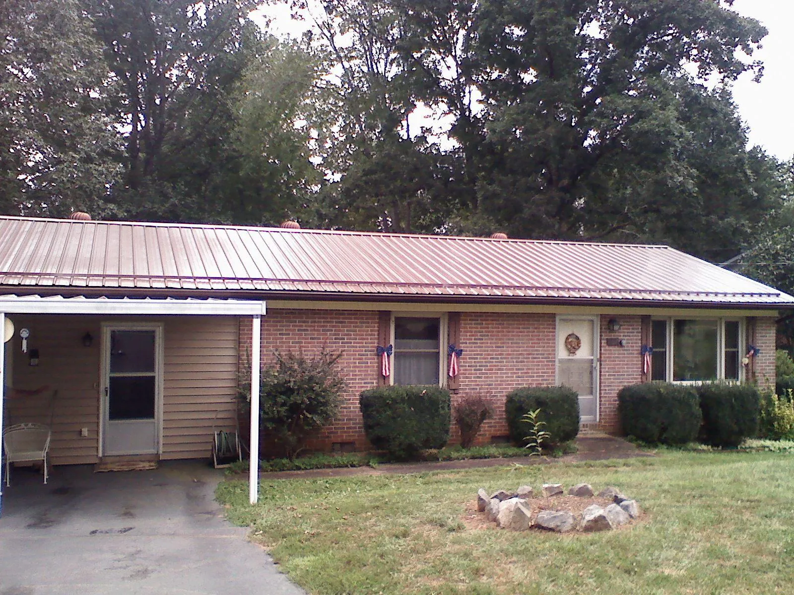Bronze metal roof and carport on a brick ranch home — Roof Repair work by our crew in Riesel